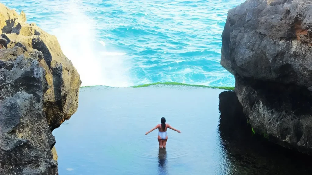 Angel Billabong Nusa Penida showing natural infinity pool against ocean backdrop with rugged coastal cliffs, reachable through Axe Stone Fast Cruise West Nusa Penida day trips from Sanur
