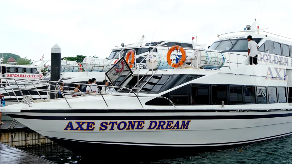 Our vessel Axe Stone Dream by Axe Stone Fast Cruise docked at Sanur Harbour, ready for Fast Boat to Nusa Penida departure with modern hull design and safety equipment visible
