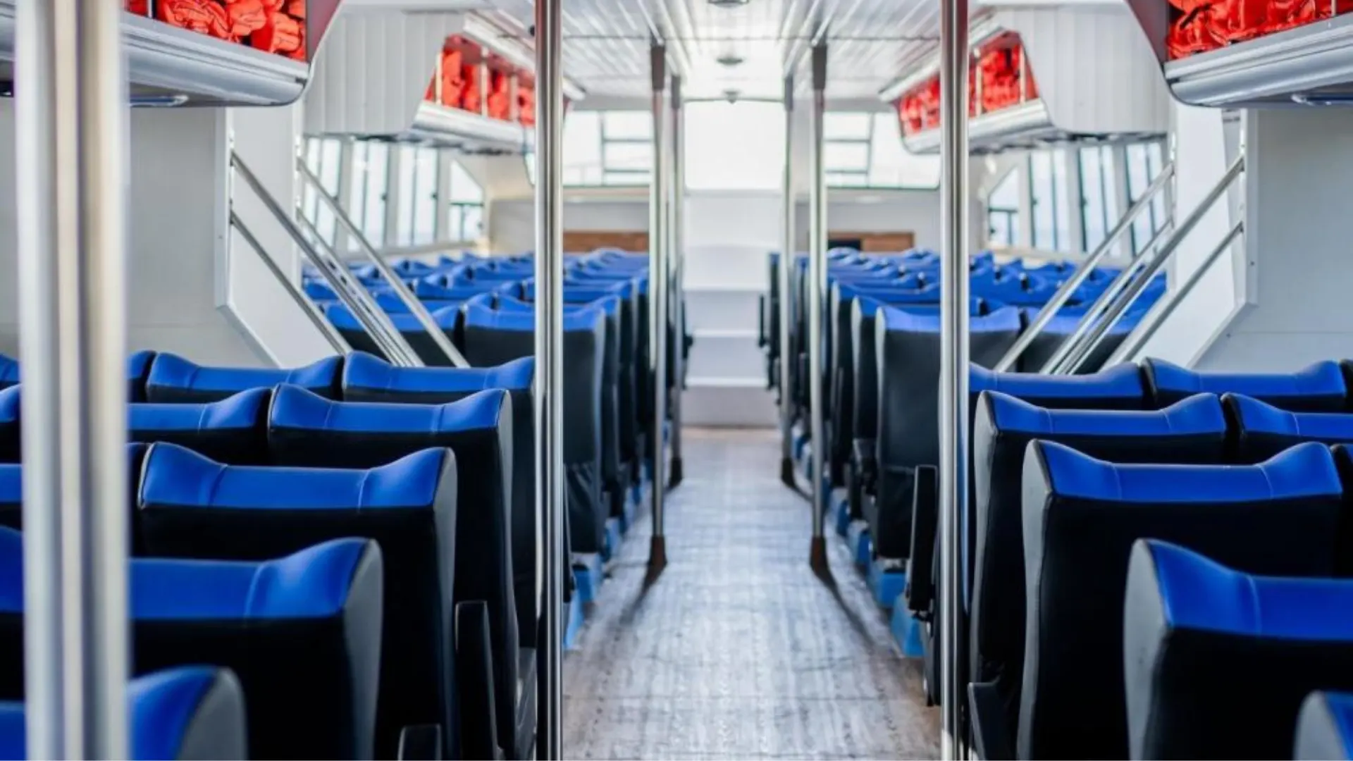 Spacious interior of Axe Stone Dream featuring comfortable blue seating for Fast Boat to Nusa Penida passengers with Axe Stone Fast Cruise, offering ample legroom and modern design