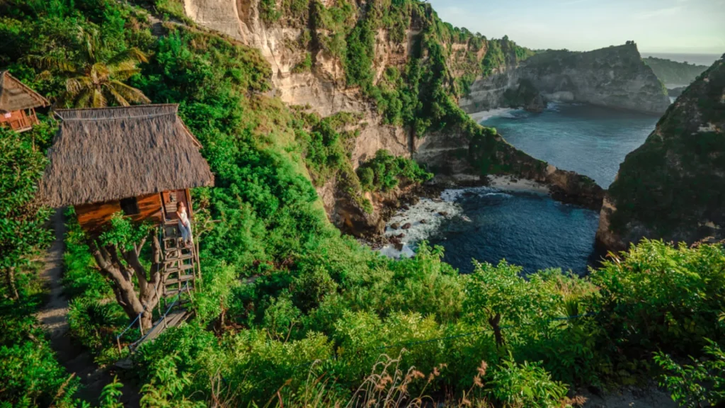 Rumah Pohon Molenteng Nusa Penida tree house framed by lush greenery with panoramic backdrop of Diamond Beach and Thousand Islands coastline, accessible via Axe Stone Fast Cruise daily departures to Banjar Nyuh Harbour for East Nusa Penida exploration