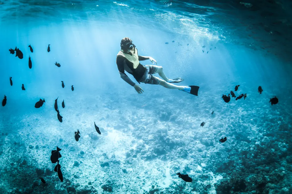 Snorkeling Package in Nusa Penida featuring a man snorkeling in pristine waters with Axestone Fast Cruise, experiencing the best snorkeling spots.