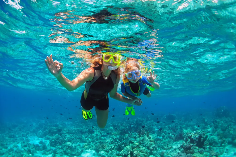 Snorkeling Nusa Penida Package with two women snorkelers enjoying underwater adventure with Axestone Fast Cruise, discovering marine life together.