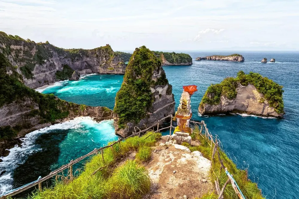 Stunning panoramic view of Thousand Island viewpoint in East Nusa Penida Tour with Axestone Fast Cruise, featuring turquoise waters and scattered small islands against dramatic coastal cliffs.